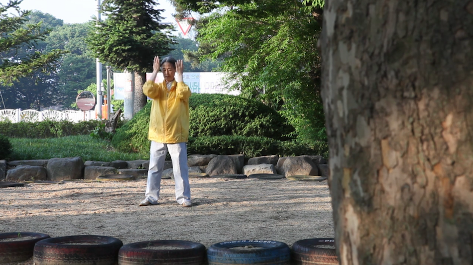 Yonghee practices the gentle Falun Gong exercises each morning. (Image via Jarrod Hall / Vimeo Screenshot)