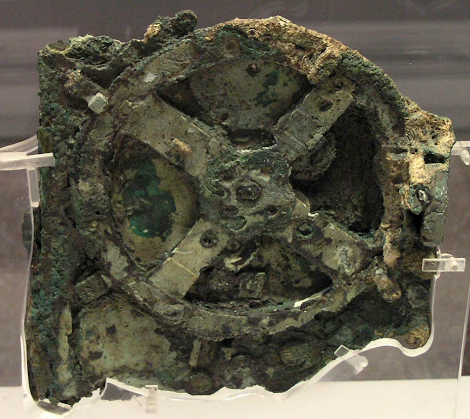 The Antikythera mechanism consists of a complex system of 30 wheels and plates with inscriptions relating to signs of the zodiac, months, eclipses and pan-Hellenic games. The study of the fragments suggests that this was a kind of astrolabe. The interpretation now generally accepted dates back to studies by Professor w:en:Derek de Solla Price, who was the first to suggest that the mechanism is a machine to calculate the solar and lunar calendar, that is to say, an ingenious machine to determine the time based on the movements of the sun and moon, their relationship (eclipses) and the movements of other stars and planets known at that time. (Image: via wikipedia / CC BY 2.5)