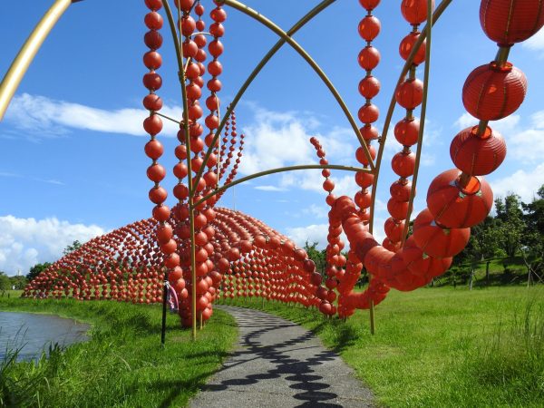 The fish-shaped red lantern tunnel looks like a miraculous big golden fish swimming in the water of the pond in the evening. (Image: Billy Shyu/ Vision Times)