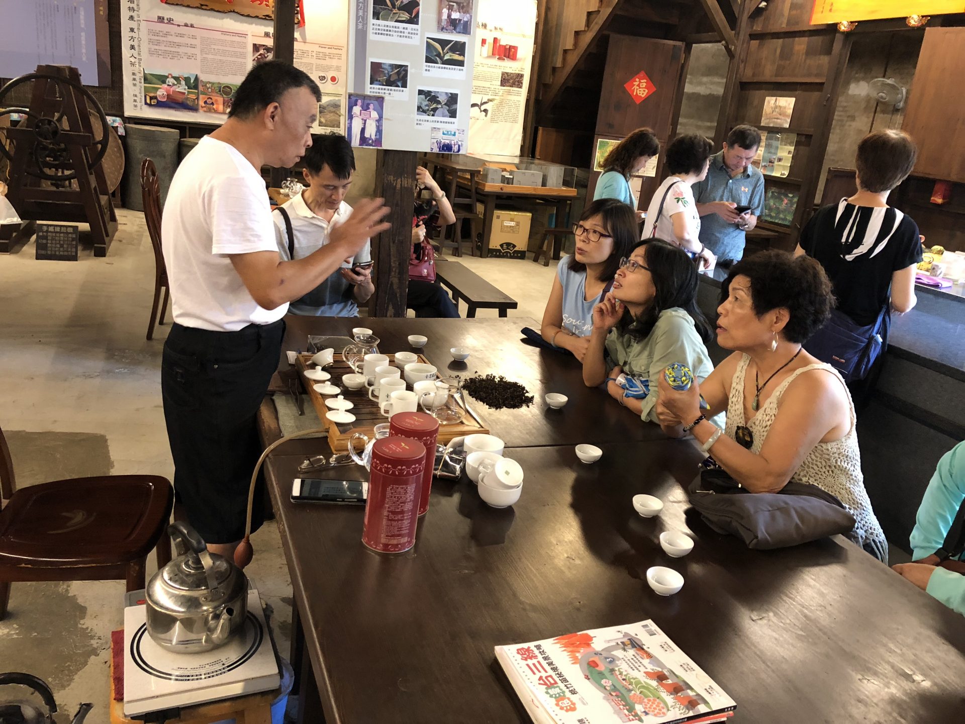 The operator of a hundred-year-old tea shop explain the history of the Oriental Beauty Tea to visitors (Image: Billy Shyu/ Vision Times)