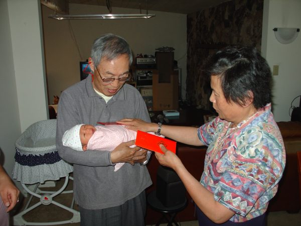 A red envelope is handed over at the birth of a child. (Image Credit: mliu92; Flickr; CC2.0)