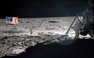 Apollo 11 Commander Neil Armstrong working at an equipment storage area on the lunar module.