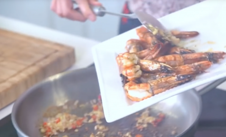 Adding the prawns to the pan.