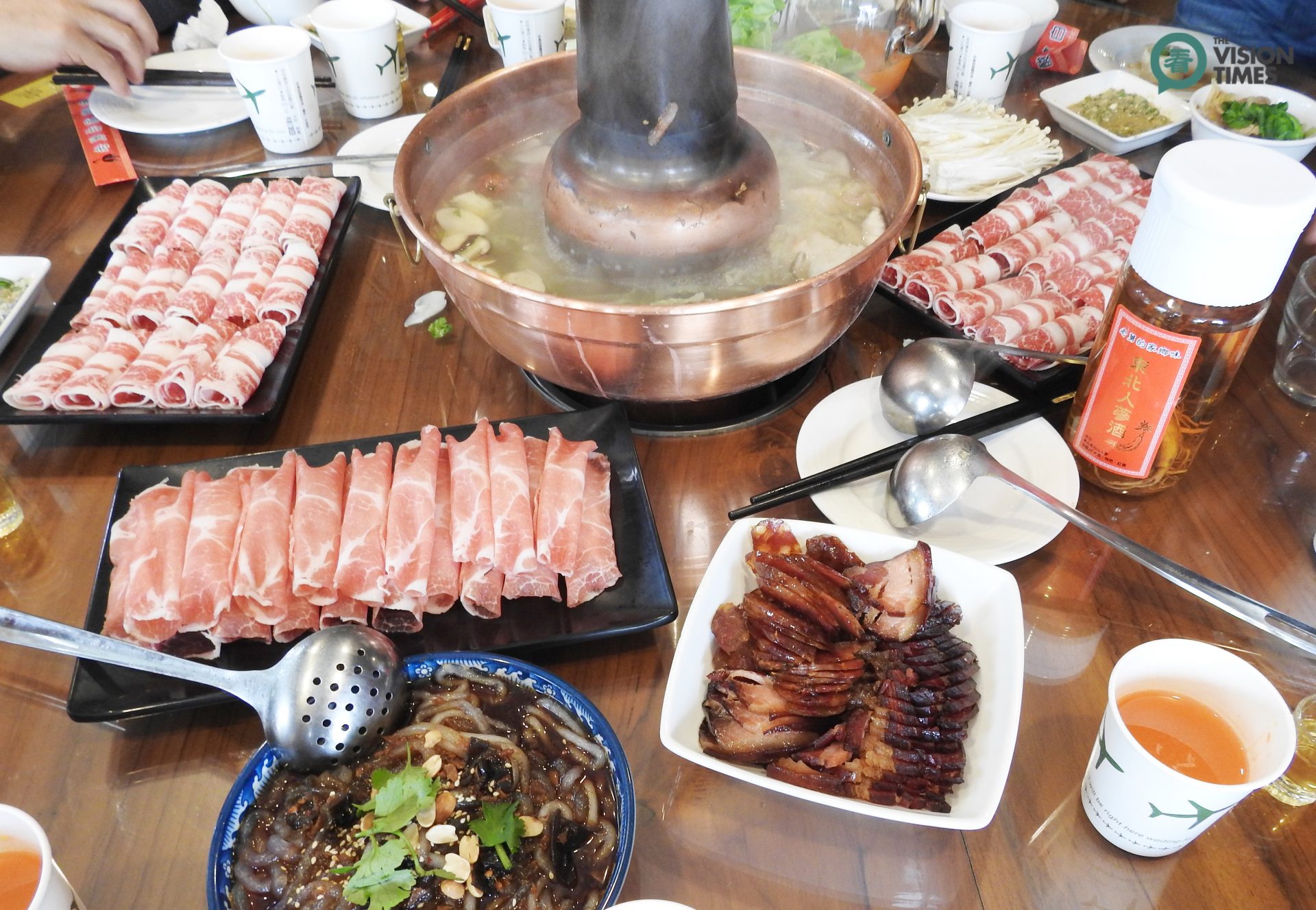 Hot pot usually consists of a simmering metal pot with broth in the middle of a dining table, and all raw ingredients are placed around the metal pot. (Image: Julia Fu / Vision Times)