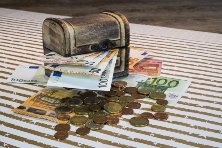 A small treasure chest with paper money and coins.