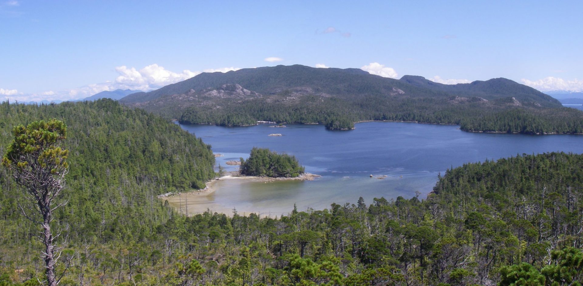 View across the beach at EjTa-4 with Calvert Island in the foreground and Hecate Island in the background. Photo by Jim Stafford.