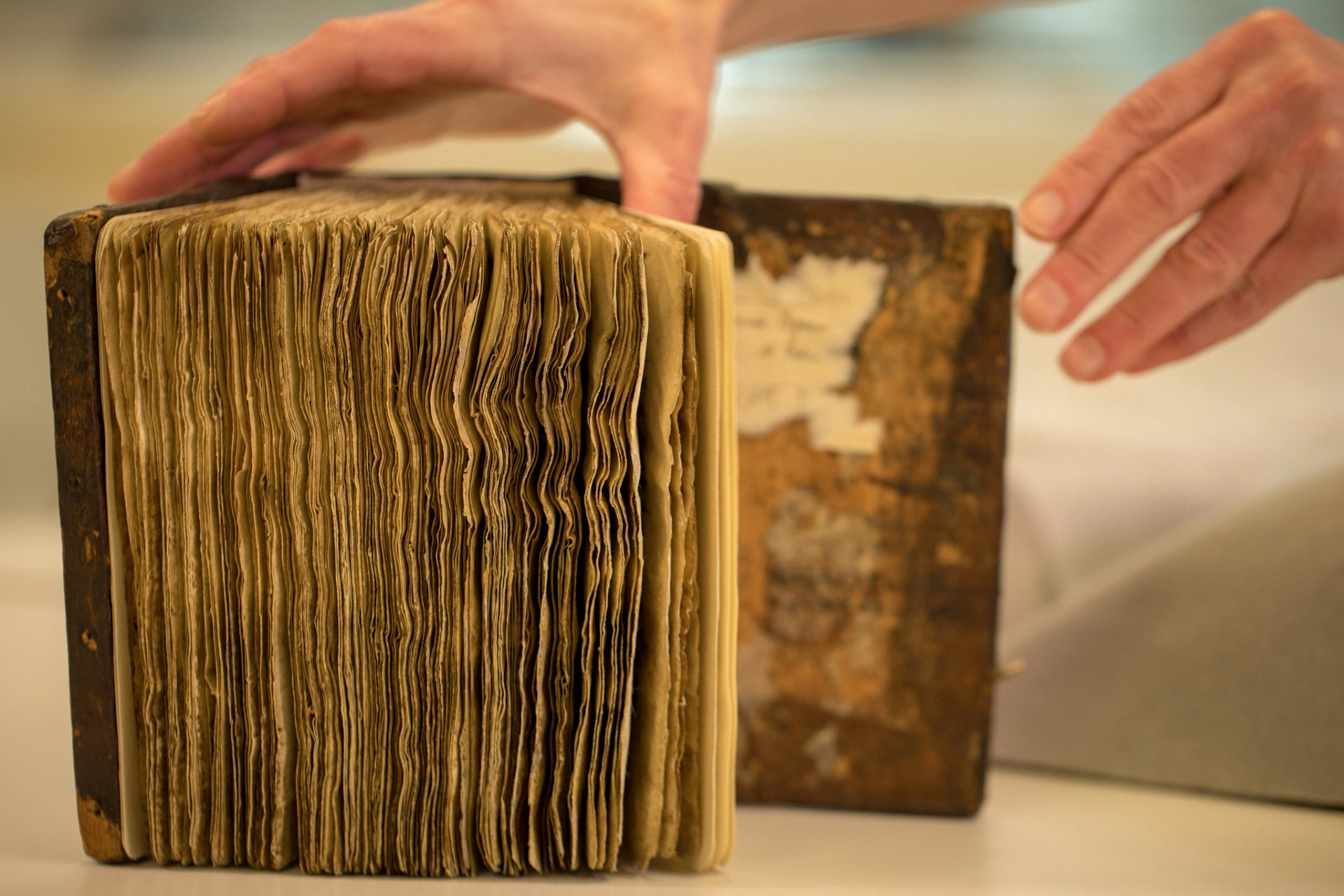 Conservators at Stanford University Libraries removed the pages from the leather-bound cover of the book of hymns, and mounted each leaf in an individually fitted, archival mat. The individual mats were placed in an aluminum frame to secure the pages while examining the underlying text with X-rays at the Stanford Synchrotron Radiation Lightsource. (Farrin Abbott / SLAC National Accelerator Laboratory)