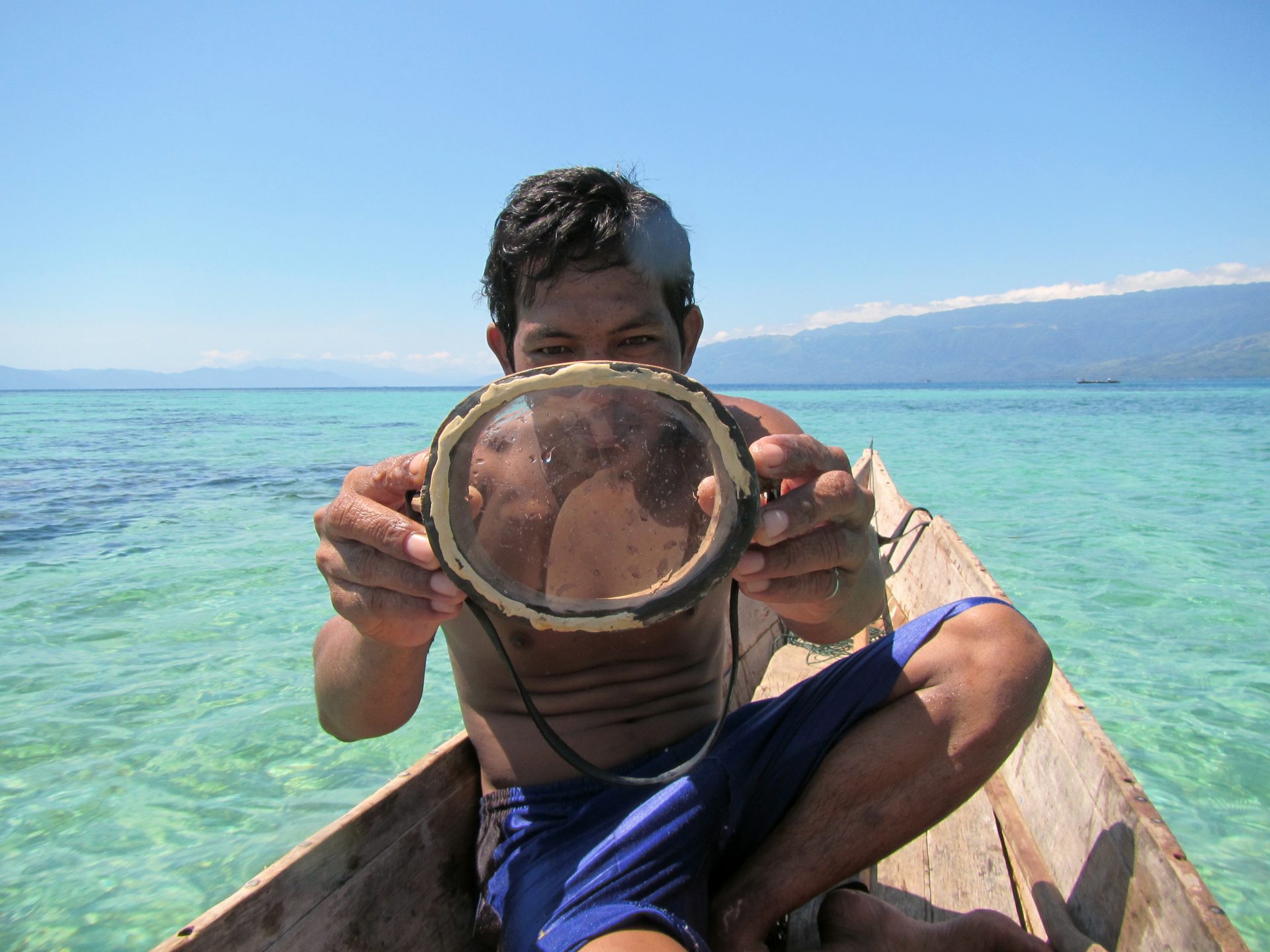 A Bajau diver displays a traditional wooden diving mask. (Photo by Melissa Ilardo)