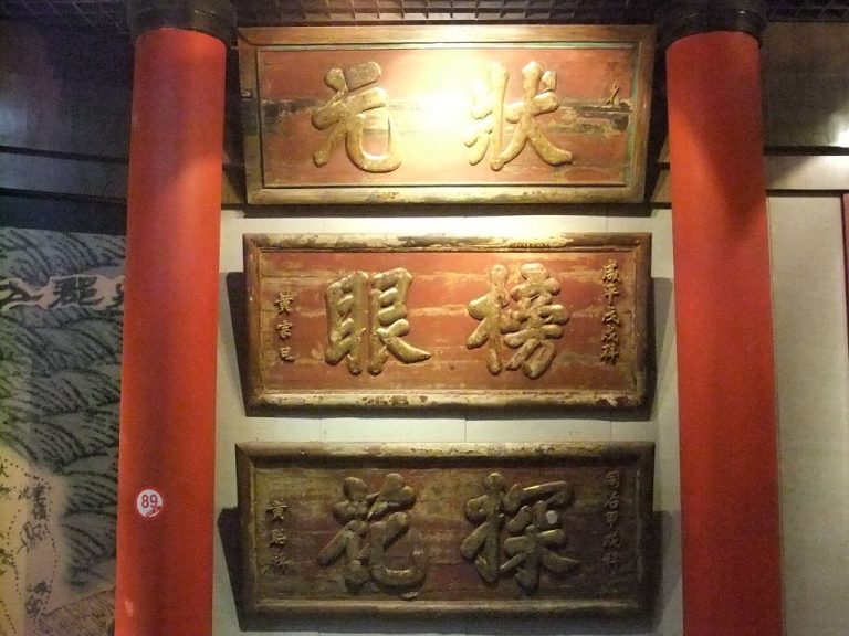 The boards are inscribed with the titles of the Imperial Exam winners awarded by the Imperial Examiner: 'Zhuang Yuan' for first place, 'Bang Yan' for second place, and 'Tan Hua” for third.