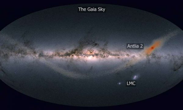 Antlia 2 is a giant, but low mass, dwarf galaxy. As Antlia 2 orbits around the Milky Way, it is likely that stars are torn from the dwarf galaxy and deposited throughout the outskirts of the Milky Way. The orange stars show the results of a computer model of Antlia 2. The background shows the Gaia satellite’s view of the entire night sky. The Large Magellanic Cloud (LMC) is visible below the Milky Way disc — although similar to Antlia 2 in size, the LMC is 10,000 times brighter. Credit: J. Sanders (Cambridge, UK) based on the image by Gaia Data Processing and Analysis Consortium (DPAC); A. Moitinho / A. F. Silva / M. Barros / C. Barata, University of Lisbon, Portugal; H. Savietto, Fork Research, Portugal Read more at: https://phys.org/news/2018-11-gaia-ghost-galaxy-door.html#jCp