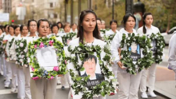 Family members march holding images of loved ones killed by the CCP. (Image: Screenshot / YouTube)