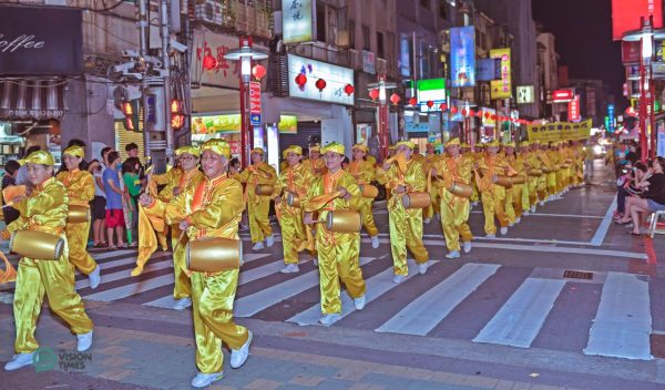 The Falun Dafa Waist Drum Team's majestic performance wins warm applause along the procession route. (Image: Johnny Lin / Vision Times)