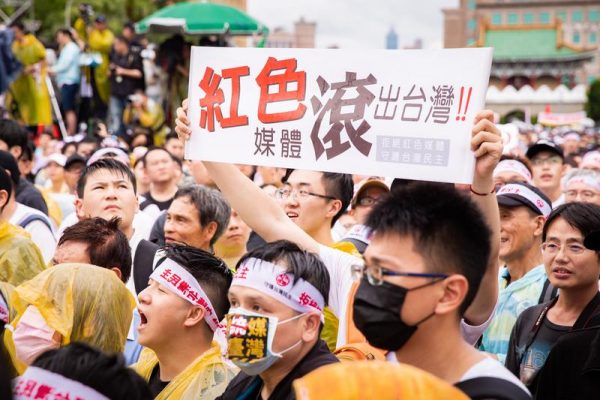 A protester holds up a sign with the words “Red Media Get Out of Taiwan” in Chinese in a rally in Taipei, Taiwan, on June 23, 2019. (Image: Chen Pochou/The Epoch Times)