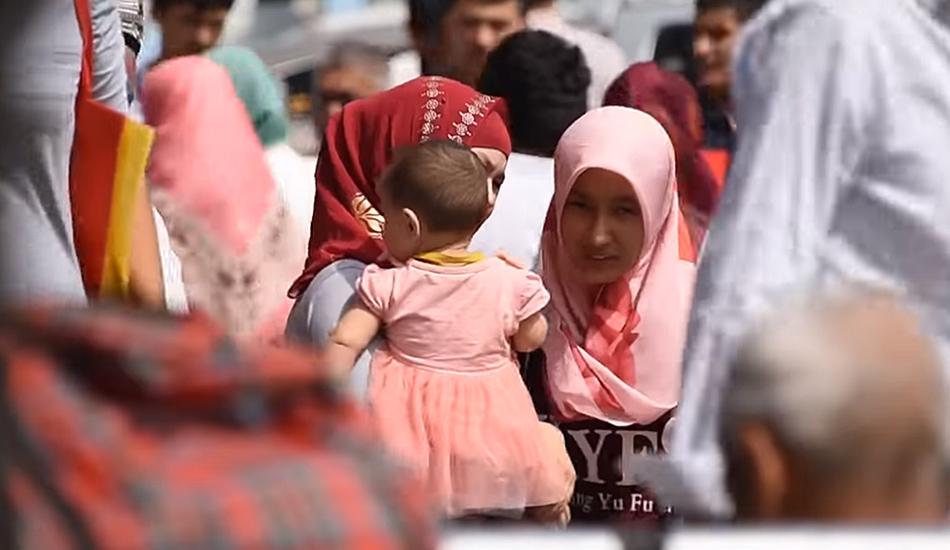 Two uyghur women with a daughter.