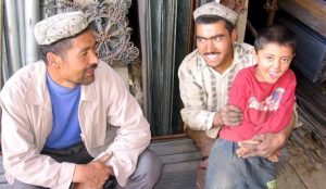 A Uyghur father and son sharing with a friend.