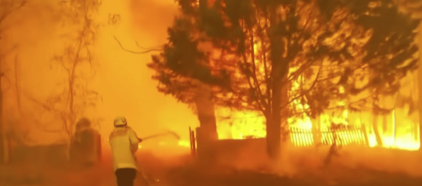 A firefighter battles the flames from an Australian wildfire. (Image: YouTube/Screenshot)