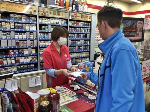A Taiwan residents picks up the face masks he ordered at a convenience store in Taiwan's Keelung City. (Image: Billy Shyu / Vision Times)