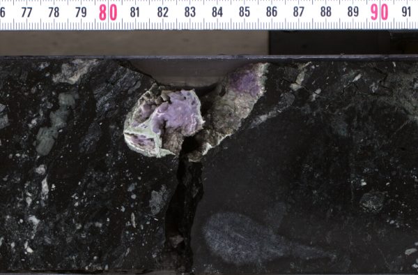 Hydrothermal minerals (silica and feldspar) in cavity within impact melt rock core. (Image: ECORD-IODP Exp 364)