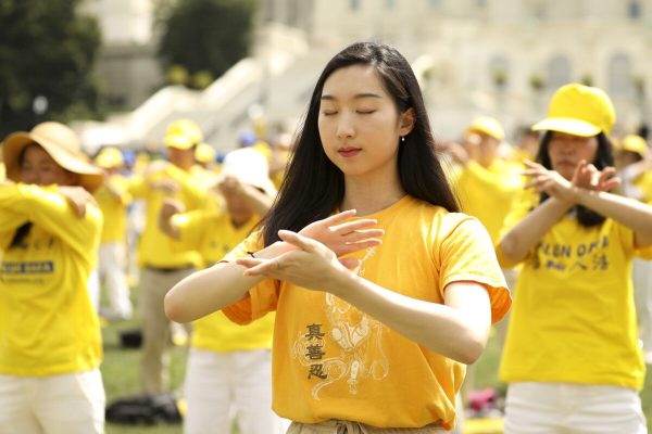 Falun Gong practitioners perform the exercises at a rally commemorating the 20th anniversary of the persecution of Falun Gong in China, on the West Lawn of Capitol Hill on July 18, 2019. (Samira Bouaou/The Epoch Times)