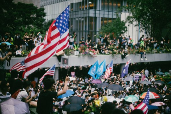 Pro-democracy protesters waving U.S. flags during a march to Hong Kong's U.S. Consulate to call for help from the Trump administration in ending a three-month confrontation with the pro-Beijing Hong Kong government, September 8, 2019. (Image: Joseph Chan/Unsplash)