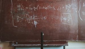 A math problem on a chalkboard.