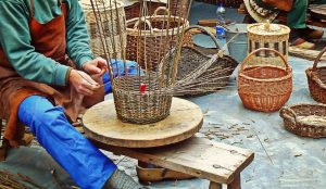 A native American weaving a basket.