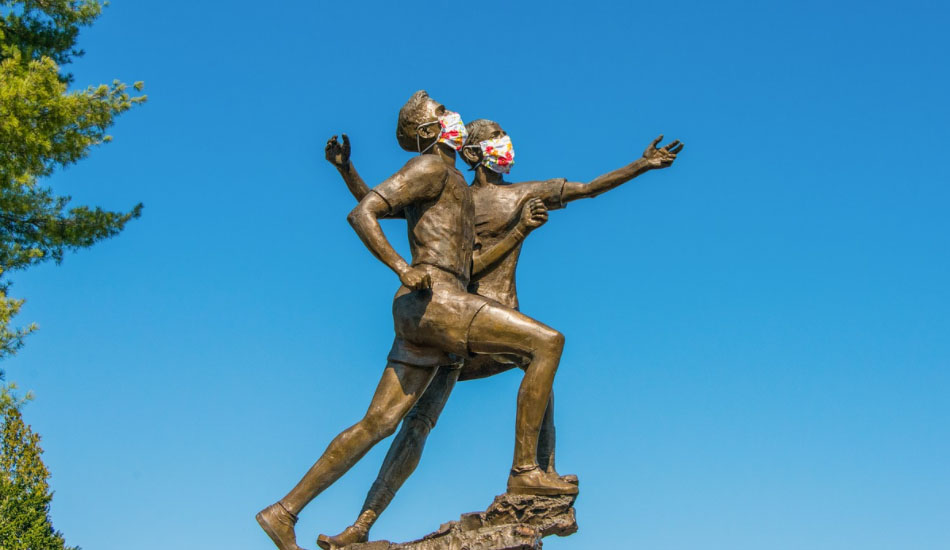 Two statues with face masks.