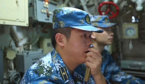 Two Chinese naval officers inside a submarine.