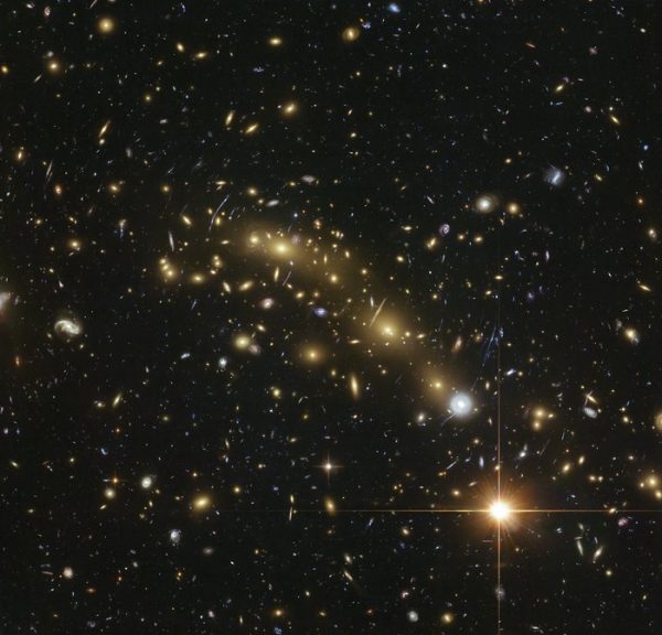This image from the NASA/ESA Hubble Space Telescope shows the galaxy cluster MACS J0416.1–2403. This is one of six being studied by the Hubble Frontier Fields programme. This programme seeks to analyse the mass distribution in these huge clusters and to use the gravitational lensing effect of these clusters, to peer even deeper into the distant Universe. A team of researchers used almost 200 images of distant galaxies, whose light has been bent and magnified by this huge cluster, combined with the depth of Hubble data to measure the total mass of this cluster more precisely than ever before. (Credit: ESA/Hubble, NASA, HST Frontier Fields Acknowledgement: Mathilde Jauzac (Durham University, UK and Astrophysics & Cosmology Research Unit, South Africa) and Jean-Paul Kneib (École Polytechnique Fédérale de Lausanne, Switzerland))