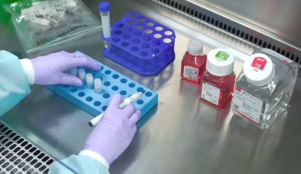 A lab tech labels vials.