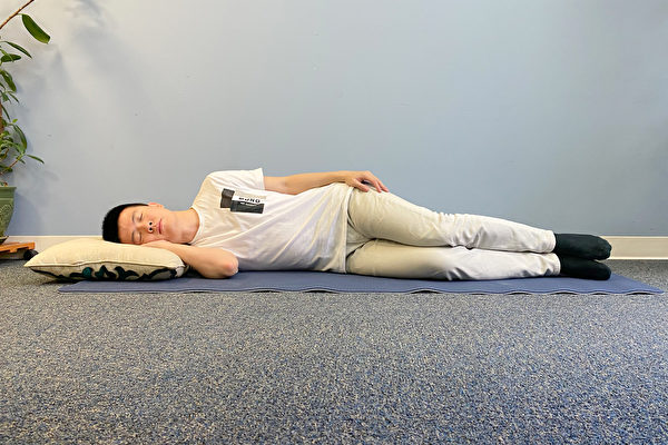 A man sleeping on his right side with legs bent.