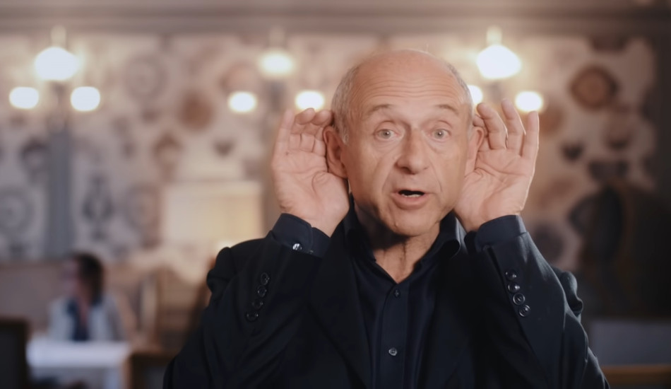 A man cupping his hands behind his ears.