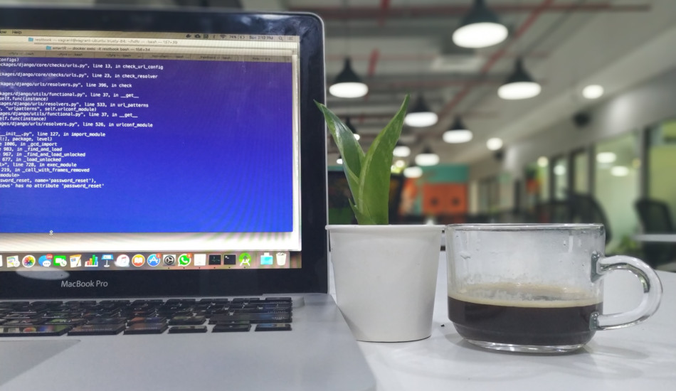 A Macbook pro sitting on a desk in an office.
