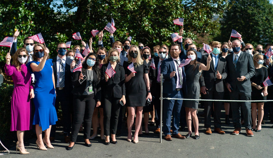 A group of people waving American flags.
