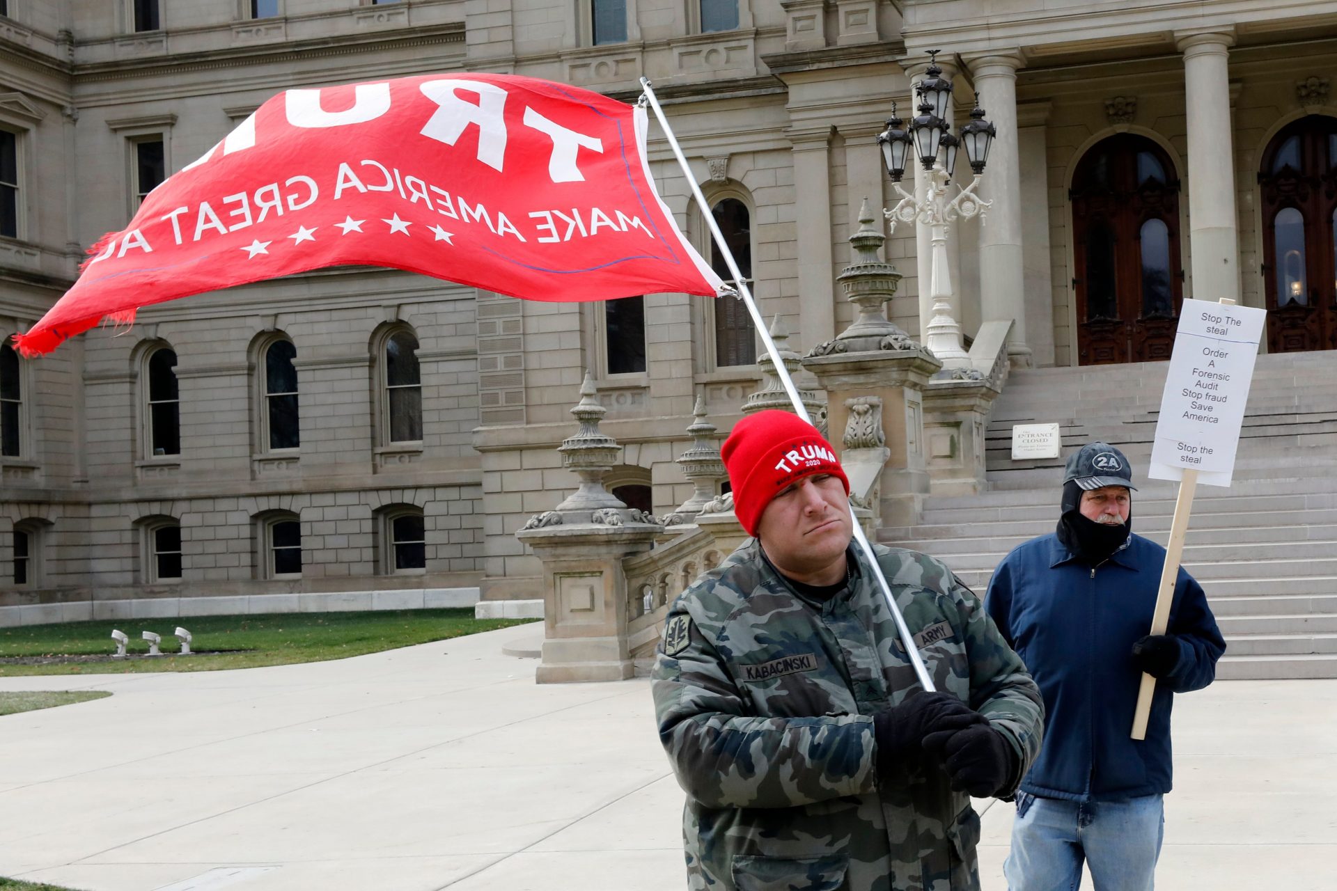 Supporters of President Donald Trump gather on the steps the Michigan state capital as the Electoral College votes in Lansing, Michigan on December 14, 2020. - Joe Biden's US election victory was set for formal confirmation by the Electoral College, further closing the door on angry efforts by President Donald Trump to overturn the 2020 vote. (Photo by JEFF KOWALSKY / AFP) (Photo by JEFF KOWALSKY/AFP via Getty Images)