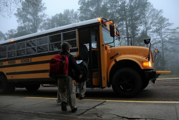 Children getting on a school bus.