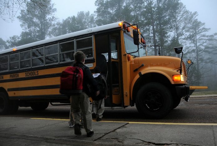 Children getting on a school bus.