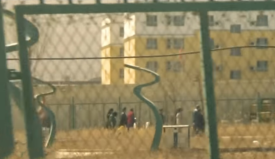 Uyghurs as seen through the fence at a detention center in Xinjiang, China.