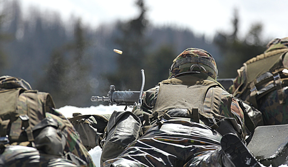 A soldier fires his weapon downrange.