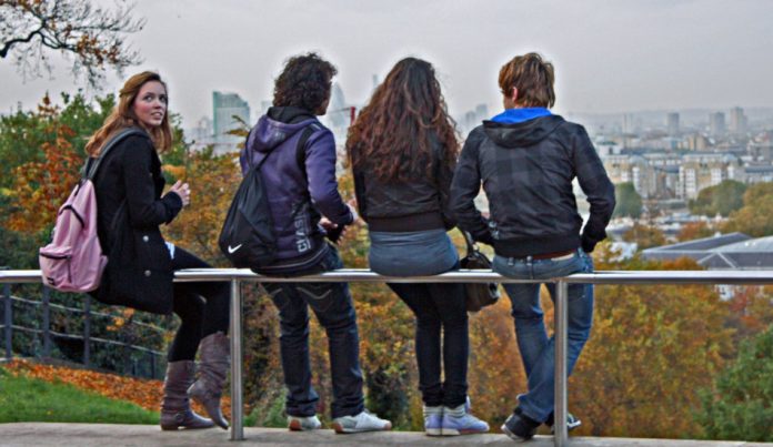 A group of young friends sit and talk together.