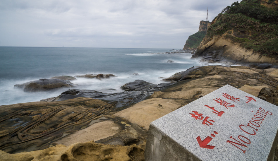A sign reads "No Crossing" on a beach in Taiwan.