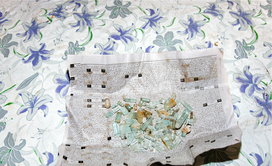 Aquamarine gems on newspaper. Pakistan.