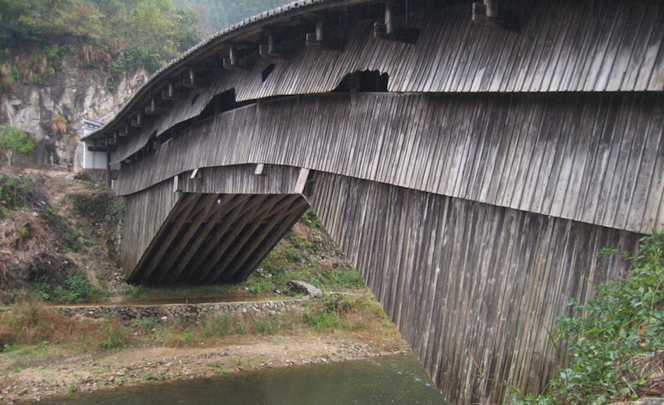 A wooden bridge in china over river named rainbow bridge.