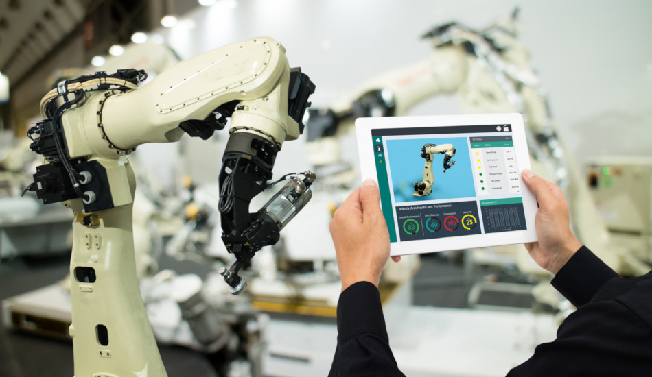 A factory worker uses a tablet to control a robotic army.