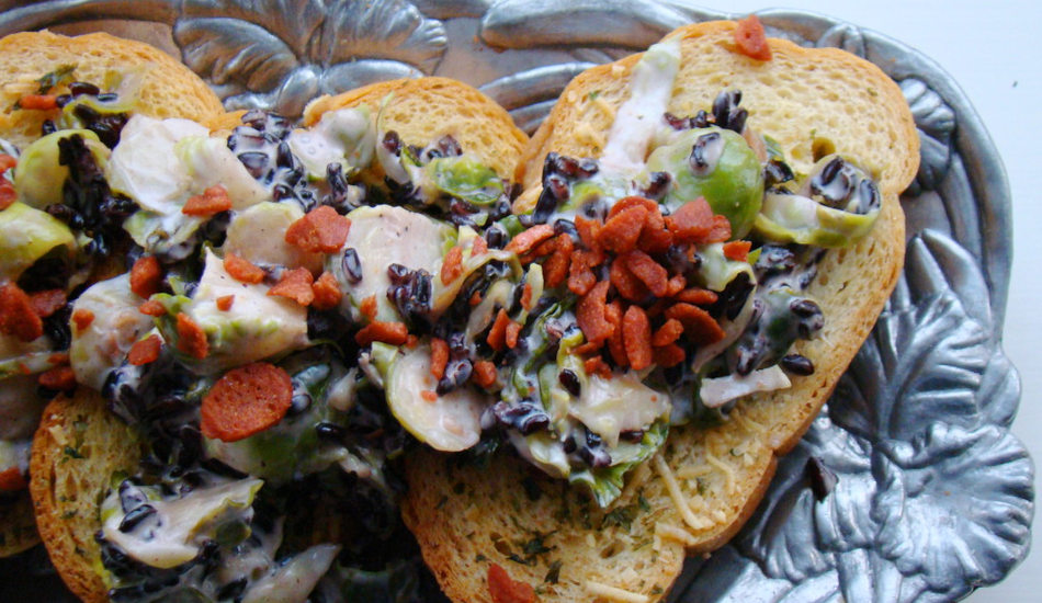 Crostini with brussels sprouts served on a silver platter.
