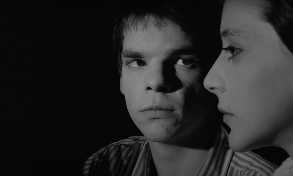 black and white film still from the film 'boy meets girl' boy gazes at girl as she looks ahead