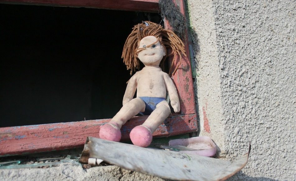 Doll looking a bit unkept in an abandoned house.