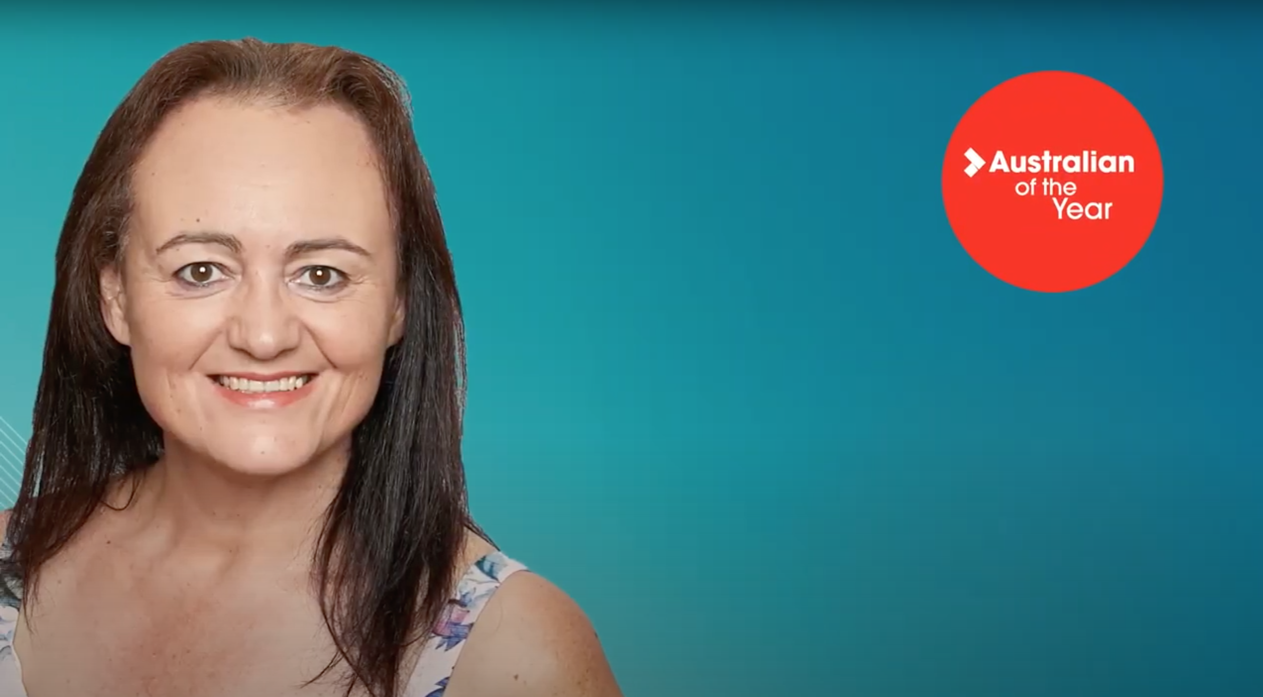 lady with shoulder length brown hair smiling, blue background
