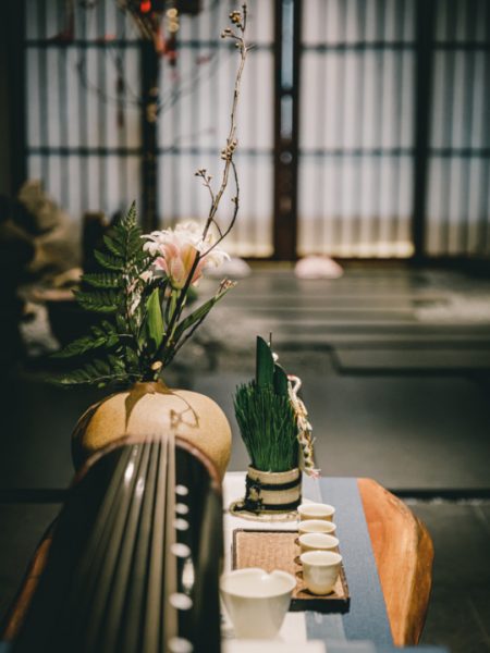 A 7-stringed guqin sits on an antique Chinese tea table.