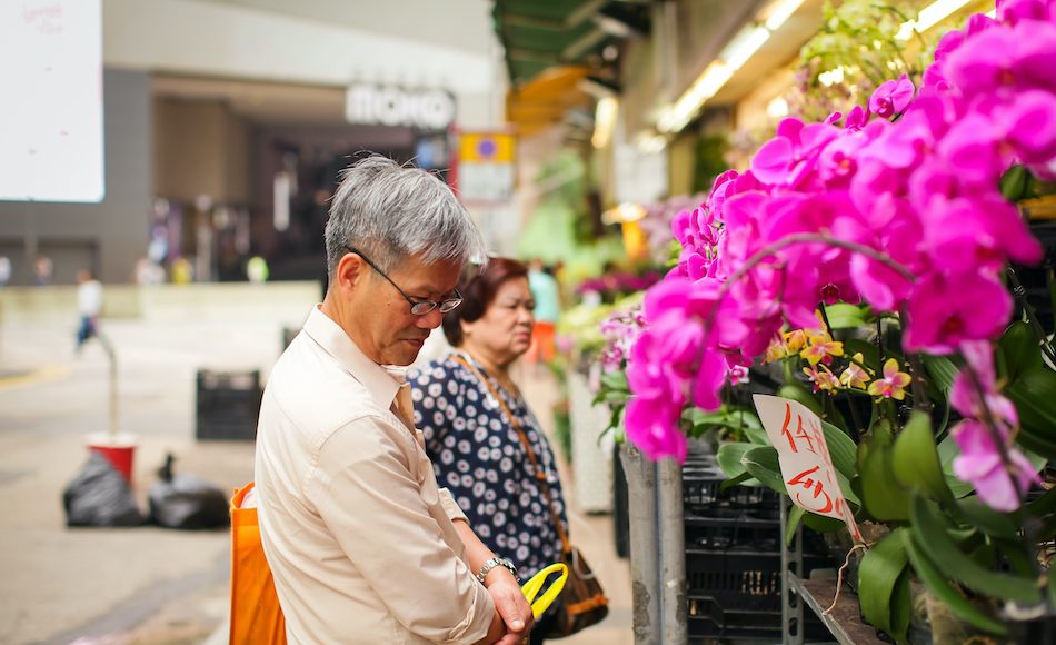 elderly man browses flowers at Hong Kong flower market